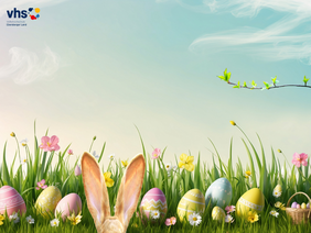 Blumenwiese mit Ostereiern und blauem Himmel. Im Vordergrund spitzen Hasenohren über den Bildrand | ©Franz Bader mit Canva Teams