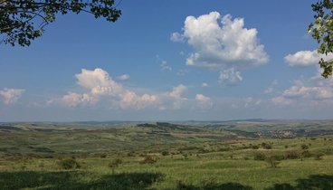 Grüne Sommerlandschaft mit weiß-blauem Himmel in Siebenbürgen
