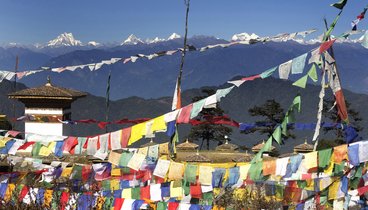 Bunte Gebetsfahnen wehen vor Bergkulisse | ©Stefan Erdmann